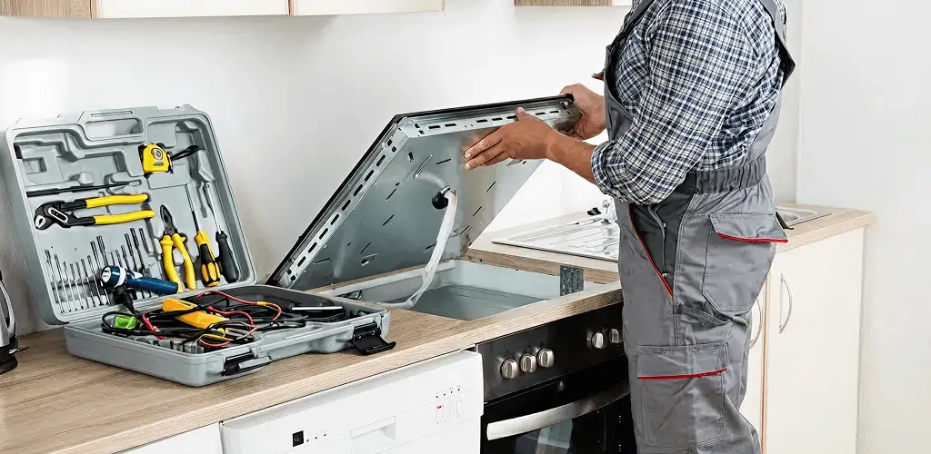 Handyman repairing a cooktop and checking wiring connections in El Paso, TX