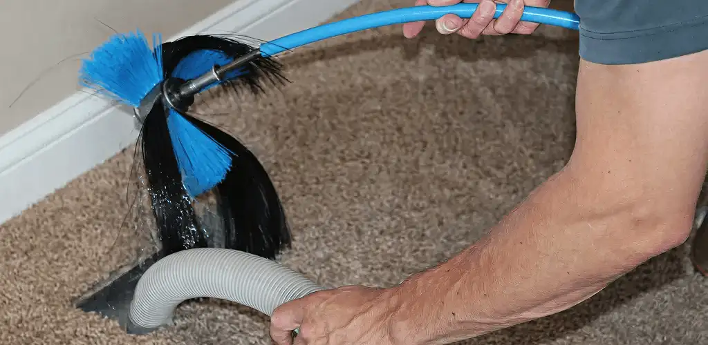 Dryer vent cleaning technician brushing lint from a vent line in El Paso, TX