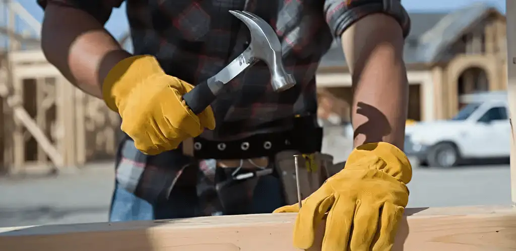 Handyman fixing wood trim with a hammer for home repairs in El Paso, TX