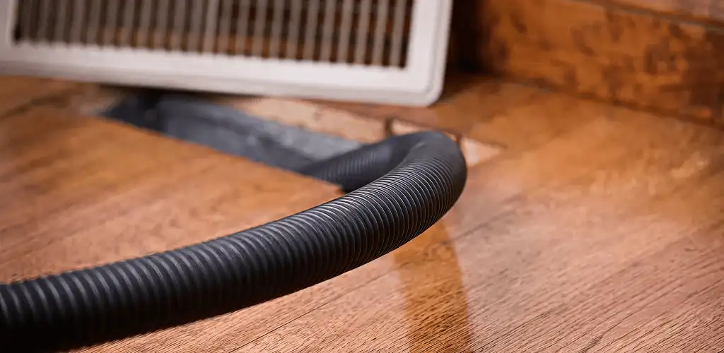Air duct cleaning hose inserted into a floor vent for ductwork cleaning in El Paso, TX
